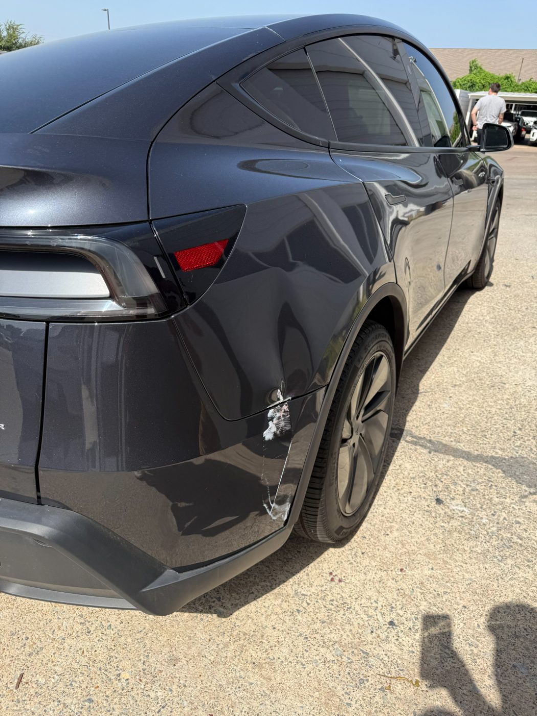 Tesla Model Y with panel damage before repair at our Plano shop.