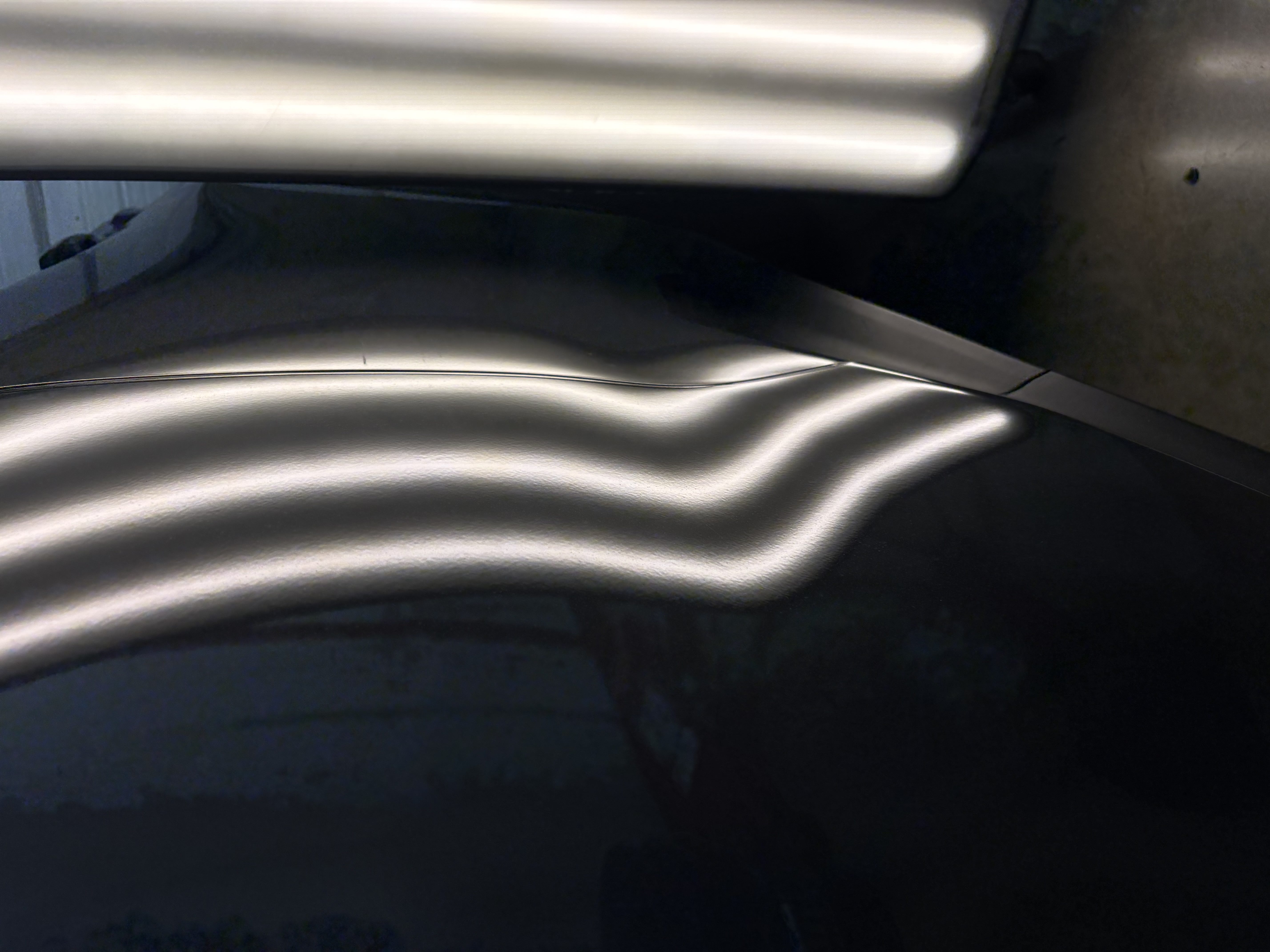 PDR line board showing a large dent bending the light lines on a dark Lincoln door